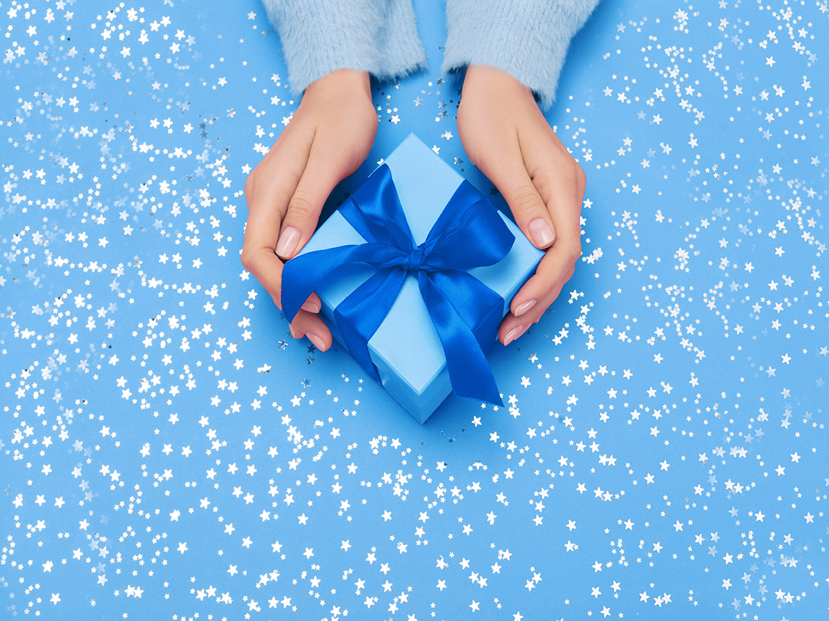 Gift box with bow in woman's hands